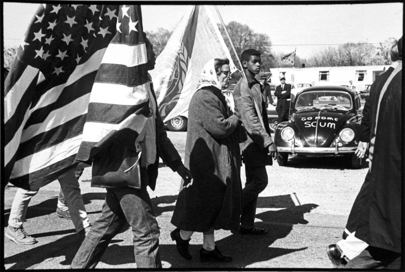 На машине, украшенной флагом Конфедерации - символа расистов Юга Америки, надпись "Убирайтесь домой, подонки".